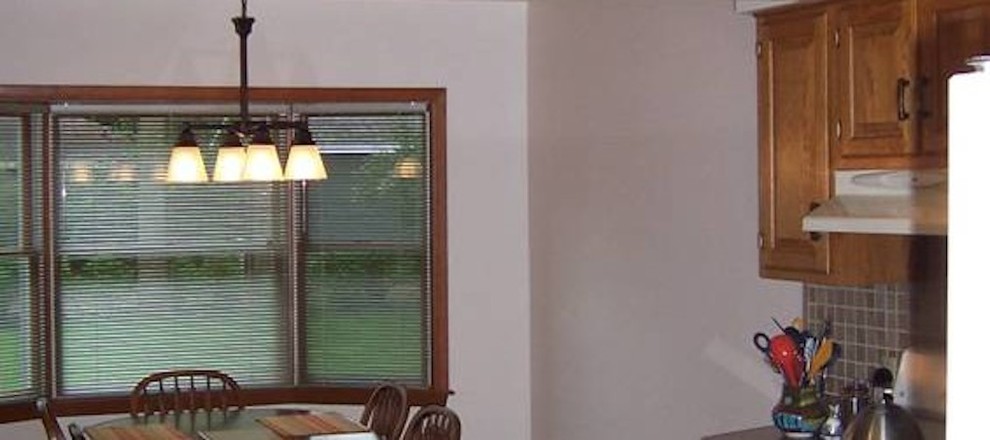 Kitchen - kitchen idea with raised-panel cabinets, medium tone wood cabinets and an island