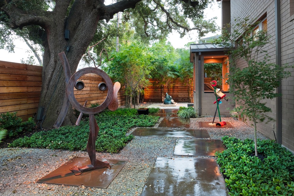 Photo of a small contemporary backyard shaded xeriscape for spring in Houston with concrete pavers.