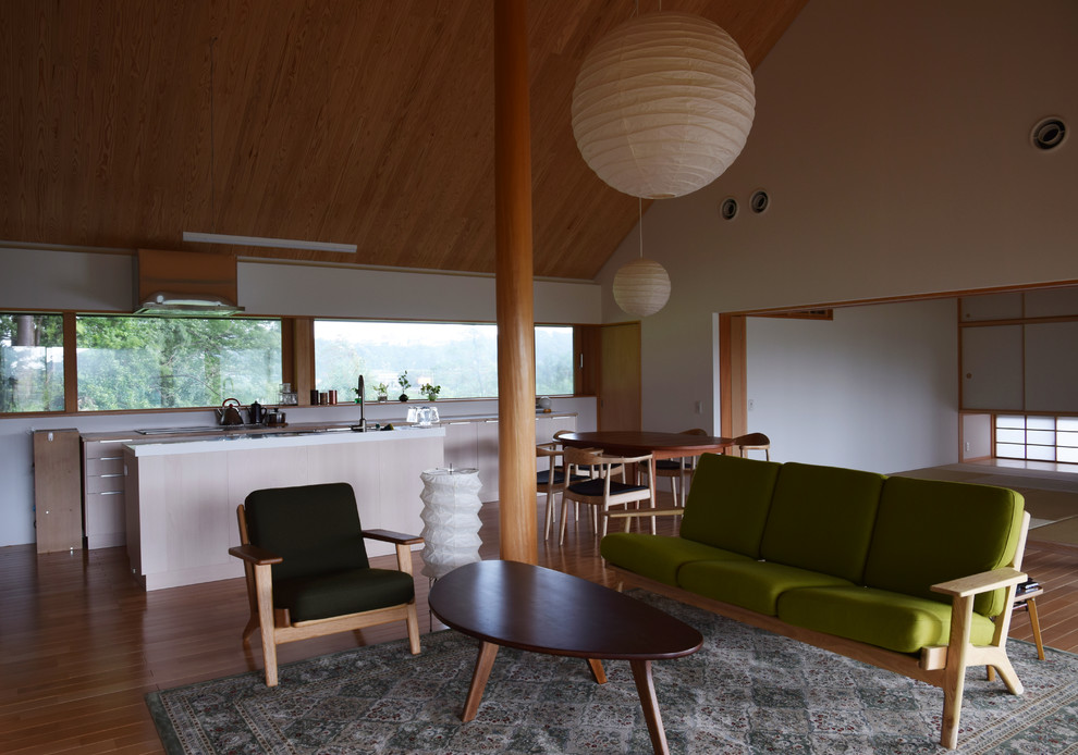 Photo of a mid-sized midcentury open concept family room in Other with white walls, medium hardwood floors, a freestanding tv and brown floor.