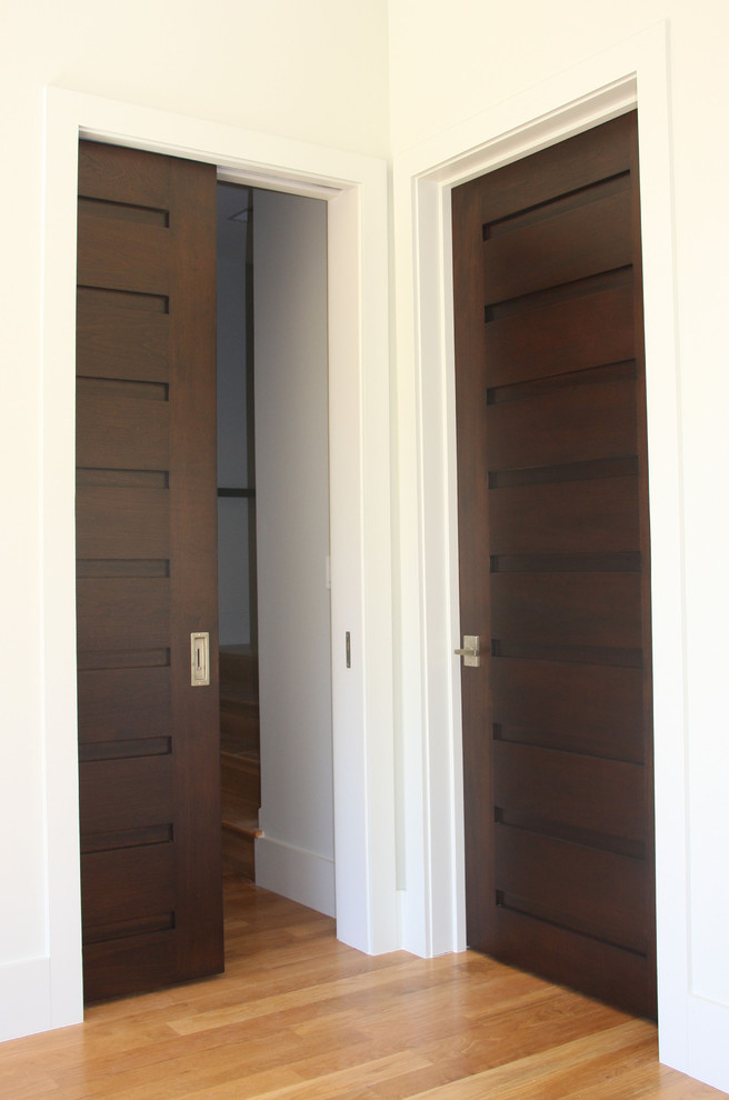 This is an example of a mid-sized country hallway in Charlotte with white walls and light hardwood floors.