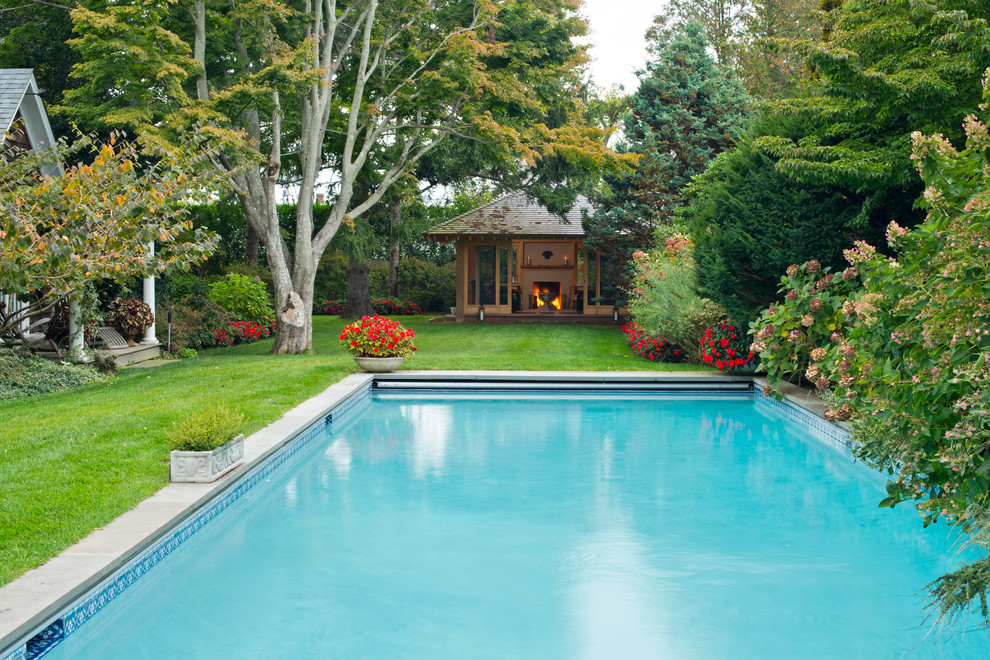 Photo of a large asian backyard rectangular pool in New York with a pool house and concrete pavers.