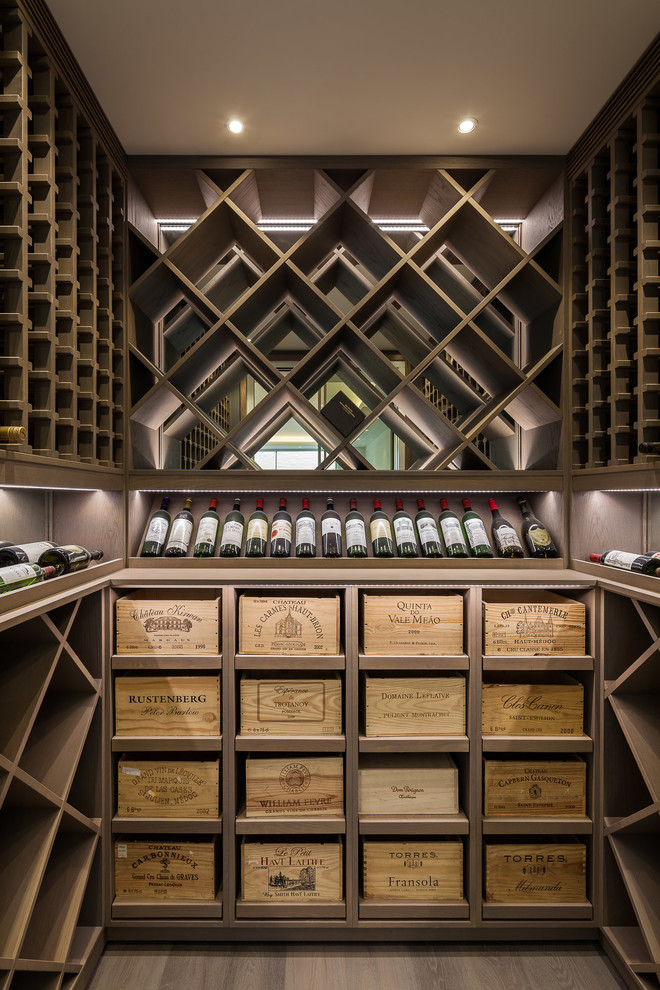 This is an example of a mid-sized contemporary wine cellar in London with display racks.