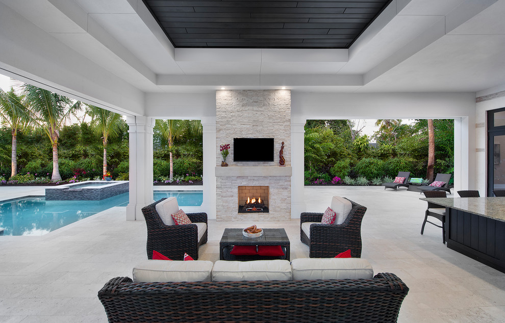Photo of an expansive transitional backyard patio in Miami with a roof extension and a fire feature.