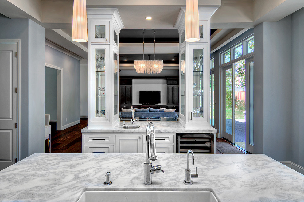 Inspiration for a large l-shaped open plan kitchen in San Francisco with a farmhouse sink, recessed-panel cabinets, white cabinets, quartzite benchtops, multi-coloured splashback, mosaic tile splashback, stainless steel appliances, medium hardwood floors and multiple islands.