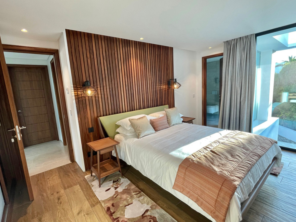 Foto de habitación de invitados minimalista grande con paredes blancas, suelo de baldosas de porcelana, bandeja y madera