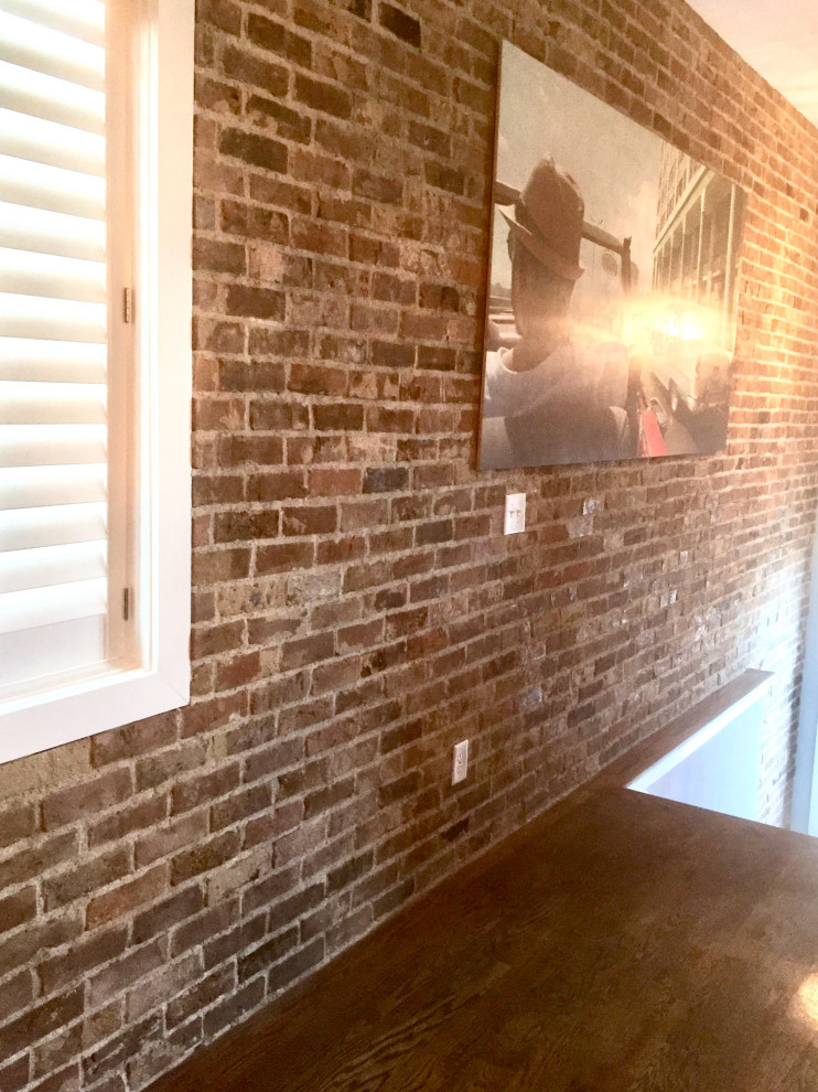 ナッシュビルにある低価格の広いラスティックスタイルのおしゃれなダイニングキッチン (茶色い壁、濃色無垢フローリング、両方向型暖炉、レンガの暖炉まわり、茶色い床、三角天井、レンガ壁) の写真