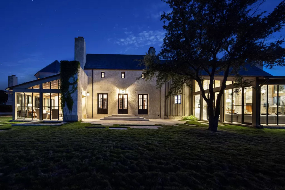 Country two-storey beige house exterior in Austin with stone veneer.