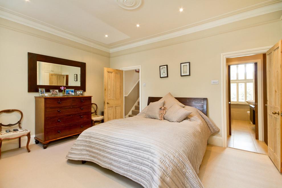 This is an example of a contemporary bedroom in Other with beige walls and carpet.