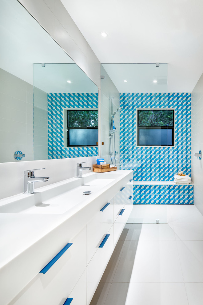 Photo of a contemporary master bathroom in Austin with flat-panel cabinets, white cabinets, white tile, cement tile, white walls, a trough sink and solid surface benchtops.