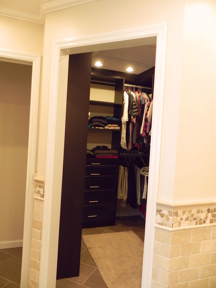 Foto de armario vestidor unisex tradicional renovado pequeño con armarios estilo shaker, puertas de armario de madera en tonos medios y suelo de baldosas de cerámica