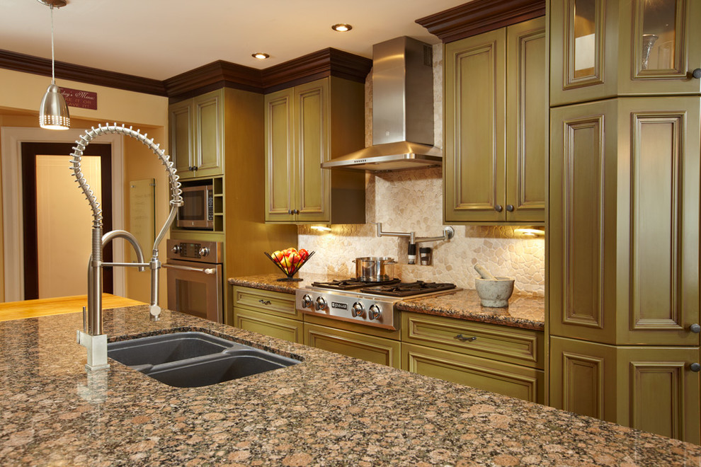 Inspiration for a mid-sized transitional l-shaped light wood floor eat-in kitchen remodel in Toronto with green cabinets, granite countertops, beige backsplash, stone tile backsplash, stainless steel appliances, an island, an undermount sink and recessed-panel cabinets