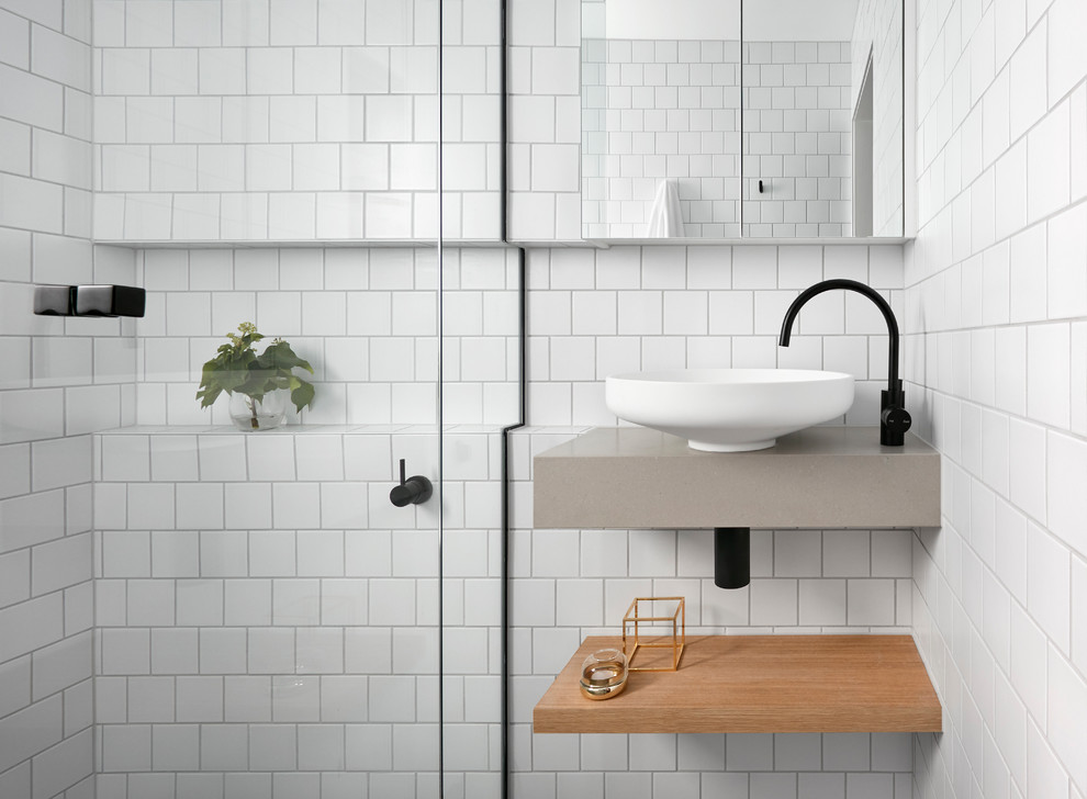 Inspiration for a small scandinavian bathroom in Melbourne with open cabinets, light wood cabinets, a curbless shower, white tile, subway tile, white walls, mosaic tile floors, a wall-mount sink, solid surface benchtops and a hinged shower door.