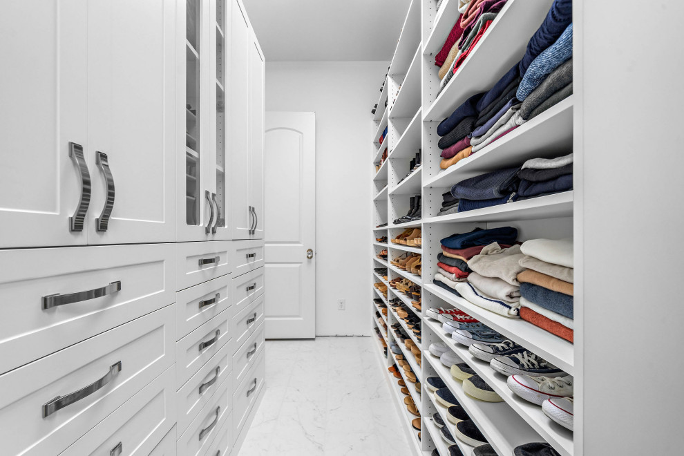This is an example of a mid-sized contemporary gender-neutral walk-in wardrobe in Houston with shaker cabinets, white cabinets, porcelain floors, white floor and recessed.