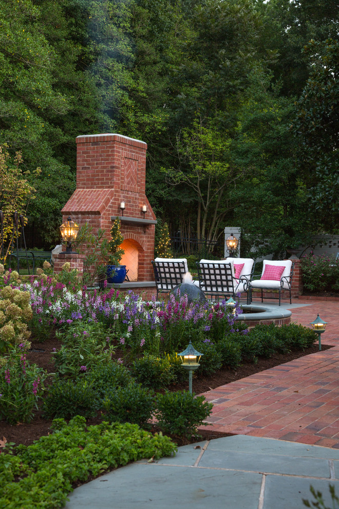 Traditional backyard patio in St Louis with brick pavers and with fireplace.