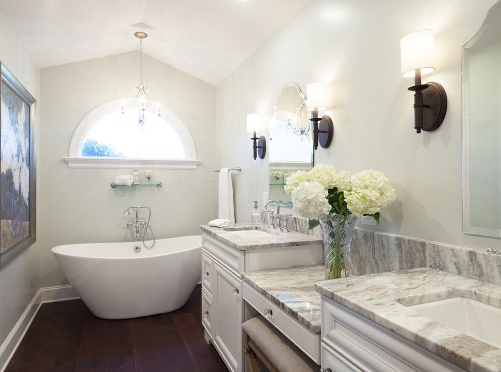 Design ideas for a large traditional master bathroom in Other with beaded inset cabinets, white cabinets, a freestanding tub, a corner shower, white tile, subway tile, white walls, dark hardwood floors, an undermount sink and engineered quartz benchtops.