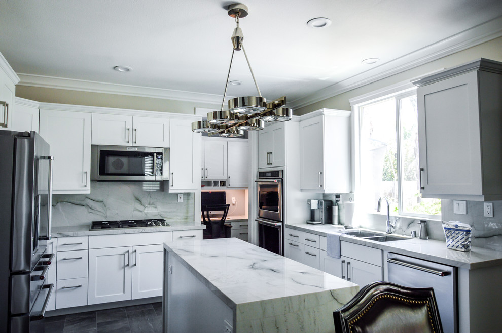 Inspiration for an expansive contemporary u-shaped kitchen in Orange County with a double-bowl sink, shaker cabinets, white cabinets, quartz benchtops, grey splashback, stainless steel appliances, porcelain floors, with island, brown floor and grey benchtop.