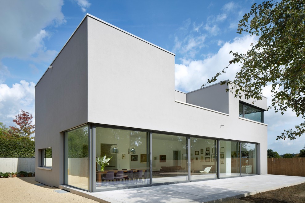 This is an example of a large contemporary two-storey stucco grey exterior in Dusseldorf with a flat roof.