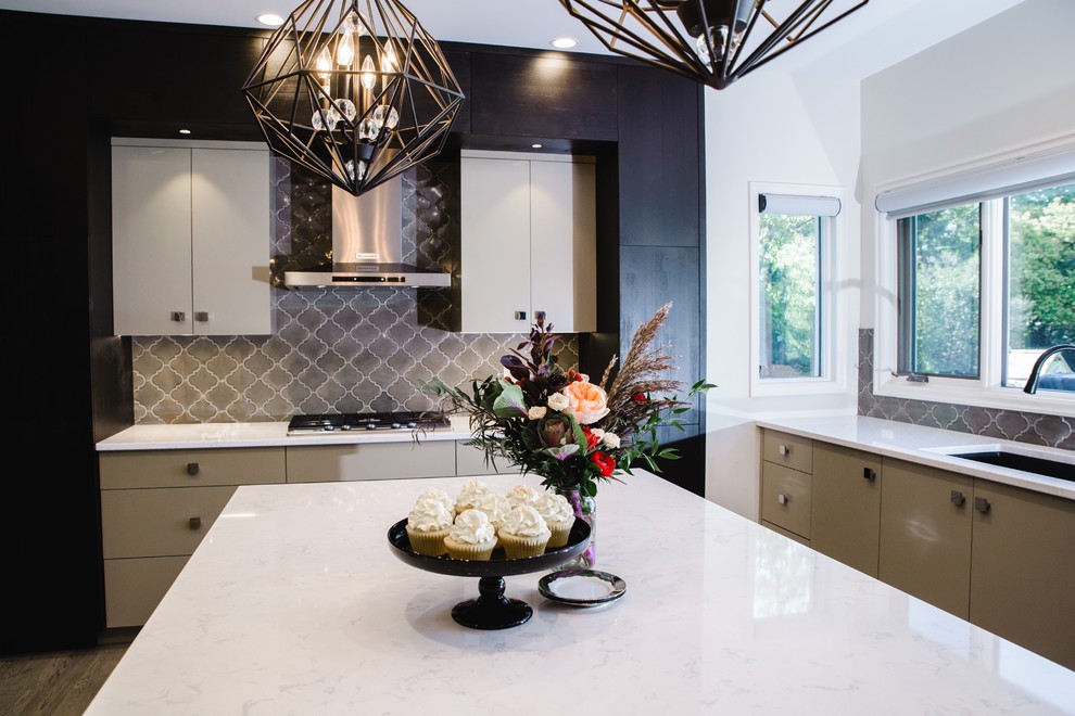 Eat-in kitchen - mid-sized eclectic u-shaped light wood floor eat-in kitchen idea with an undermount sink, flat-panel cabinets, white cabinets, solid surface countertops, gray backsplash, porcelain backsplash, stainless steel appliances and an island