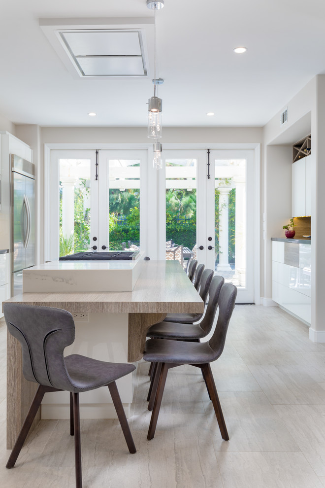 Mid-sized contemporary kitchen in Orange County with flat-panel cabinets, white cabinets, with island, white benchtop, white splashback, marble splashback, stainless steel appliances and marble benchtops.