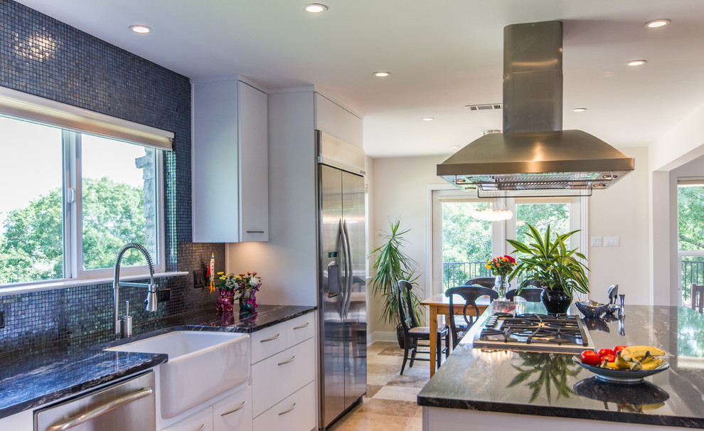 Design ideas for a mid-sized contemporary open plan kitchen in Austin with white cabinets, with island, a farmhouse sink, marble benchtops, blue splashback, mosaic tile splashback, stainless steel appliances, porcelain floors, flat-panel cabinets, beige floor and black benchtop.