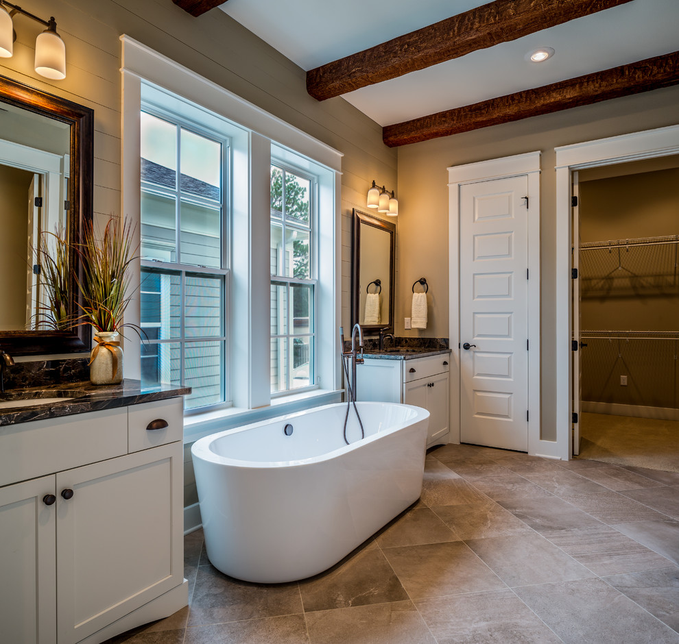 This is an example of a large country master bathroom in Miami with shaker cabinets, white cabinets, a freestanding tub, an alcove shower, beige walls, travertine floors, an undermount sink and marble benchtops.
