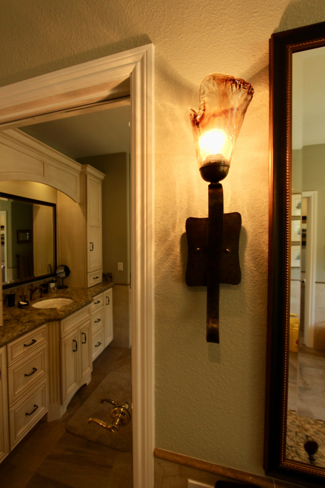 This is an example of a large classic ensuite bathroom in San Francisco with recessed-panel cabinets, beige cabinets, a submerged bath, a corner shower, a two-piece toilet, beige tiles, porcelain tiles, green walls, porcelain flooring, a submerged sink, engineered stone worktops, brown floors, a hinged door, beige worktops, a shower bench, a single sink and a built in vanity unit.