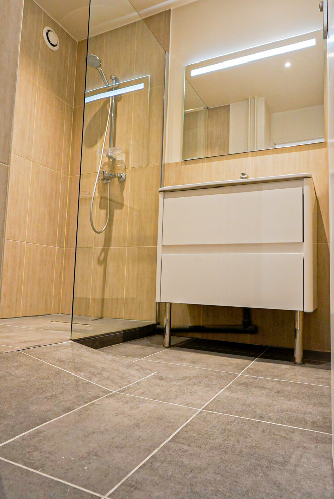 Inredning av ett modernt mellanstort brun brunt badrum med dusch, med luckor med infälld panel, beige skåp, våtrum, en vägghängd toalettstol, brun kakel, marmorkakel, bruna väggar, klinkergolv i keramik, ett undermonterad handfat, bänkskiva i akrylsten, grått golv och dusch med gångjärnsdörr