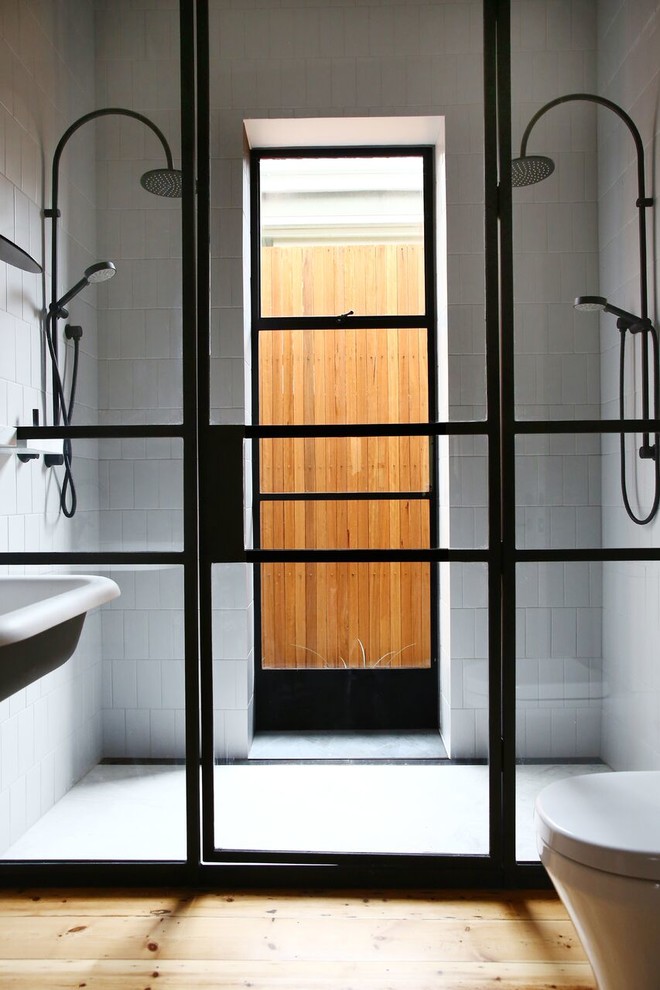This is an example of a contemporary master bathroom in Adelaide with a double shower, gray tile, grey walls, light hardwood floors, a wall-mount sink and marble benchtops.