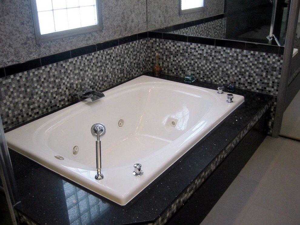 Mid-sized contemporary master bathroom in Chicago with a hot tub, black tile, black and white tile, gray tile, multi-coloured tile, white tile, mosaic tile, grey walls, porcelain floors and quartzite benchtops.