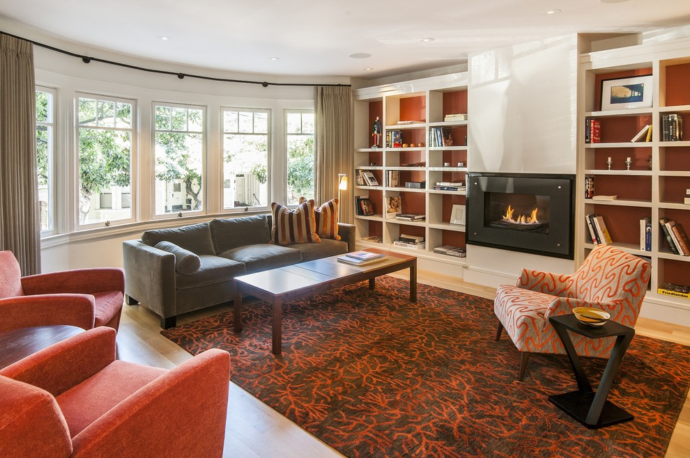 Photo of a large contemporary formal enclosed living room in San Francisco with orange walls, light hardwood floors, a ribbon fireplace, a plaster fireplace surround and no tv.