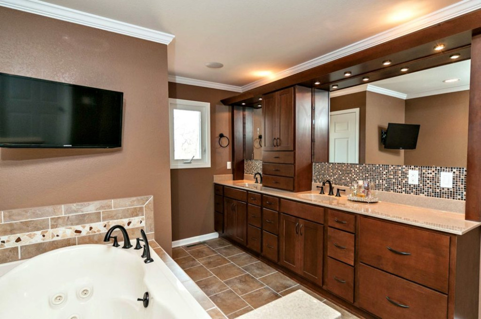This is an example of a large traditional master wet room bathroom in Chicago with shaker cabinets, dark wood cabinets, a drop-in tub, brown tile, ceramic tile, brown walls, ceramic floors, a drop-in sink, onyx benchtops, brown floor, a hinged shower door, beige benchtops, a double vanity and a built-in vanity.