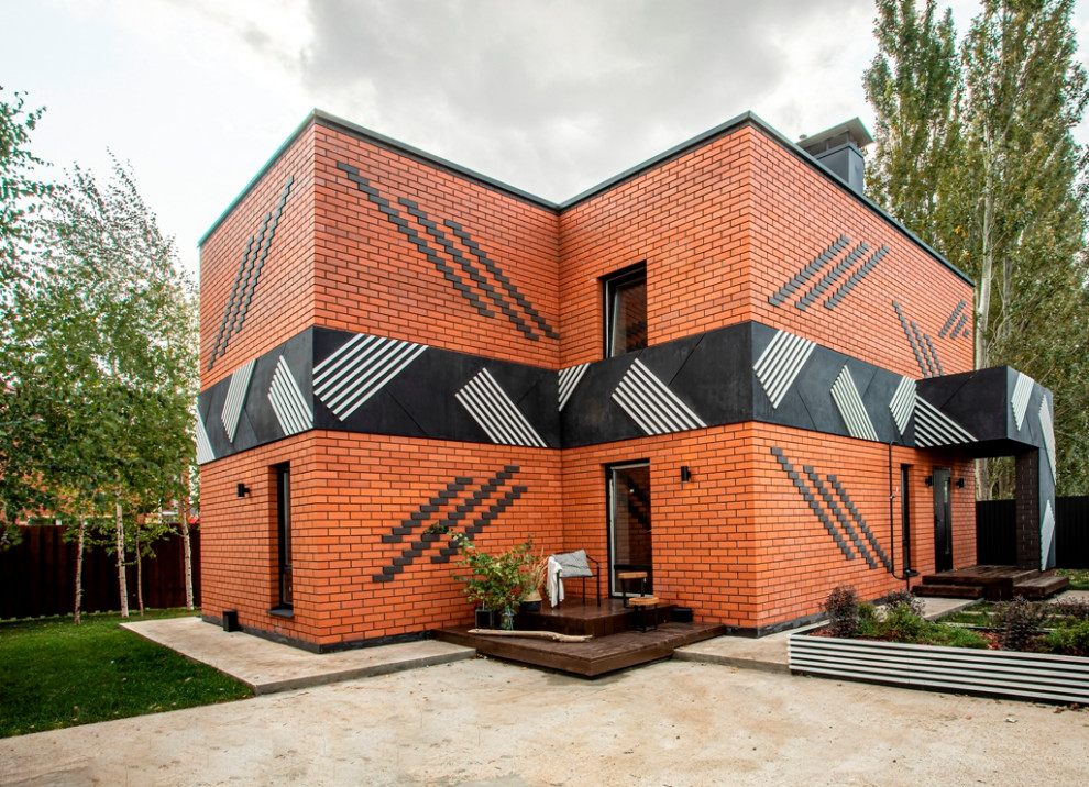 Inspiration for a contemporary two-storey brick exterior in Other with a flat roof.