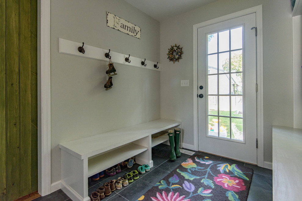 Photo of a mid-sized traditional mudroom in New York with white walls, slate floors, a single front door and a white front door.