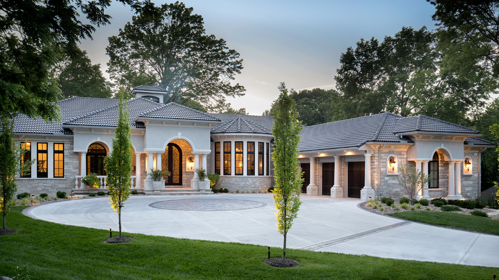 Large contemporary two-storey grey exterior in Kansas City with stone veneer and a hip roof.