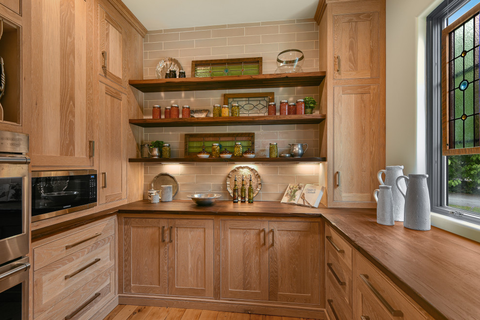 Inspiration for a large country kitchen pantry in Atlanta with shaker cabinets, light wood cabinets, wood benchtops, beige splashback, porcelain splashback, stainless steel appliances, medium hardwood floors, brown benchtop and wood.
