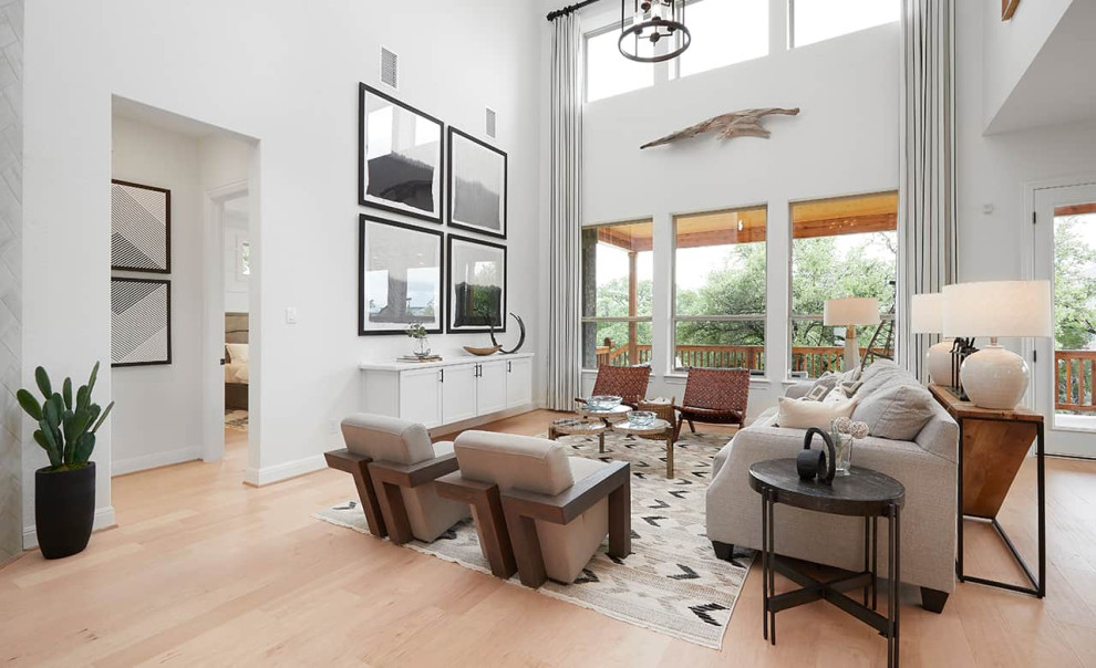 Design ideas for a contemporary open concept family room in Austin with white walls, laminate floors and brown floor.