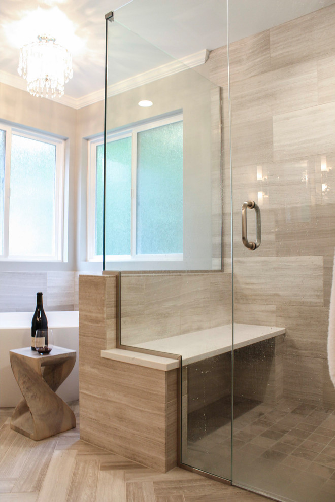 Freestanding bathtub - large transitional master limestone tile limestone floor and beige floor freestanding bathtub idea in Denver with brown cabinets, quartz countertops, a hinged shower door, shaker cabinets, gray walls and an undermount sink