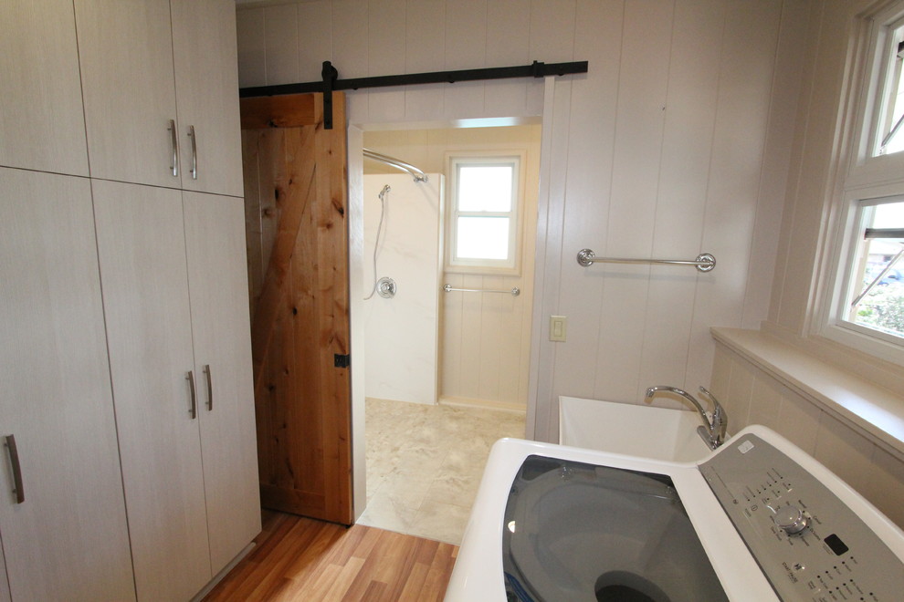 Mid-sized transitional single-wall utility room in Hawaii with an utility sink, white walls, medium hardwood floors and a side-by-side washer and dryer.