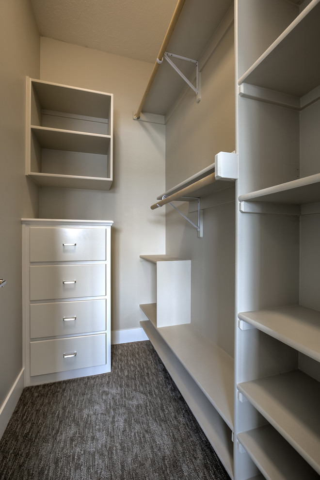 Design ideas for a small transitional gender-neutral walk-in wardrobe in Omaha with white cabinets, carpet, grey floor and open cabinets.
