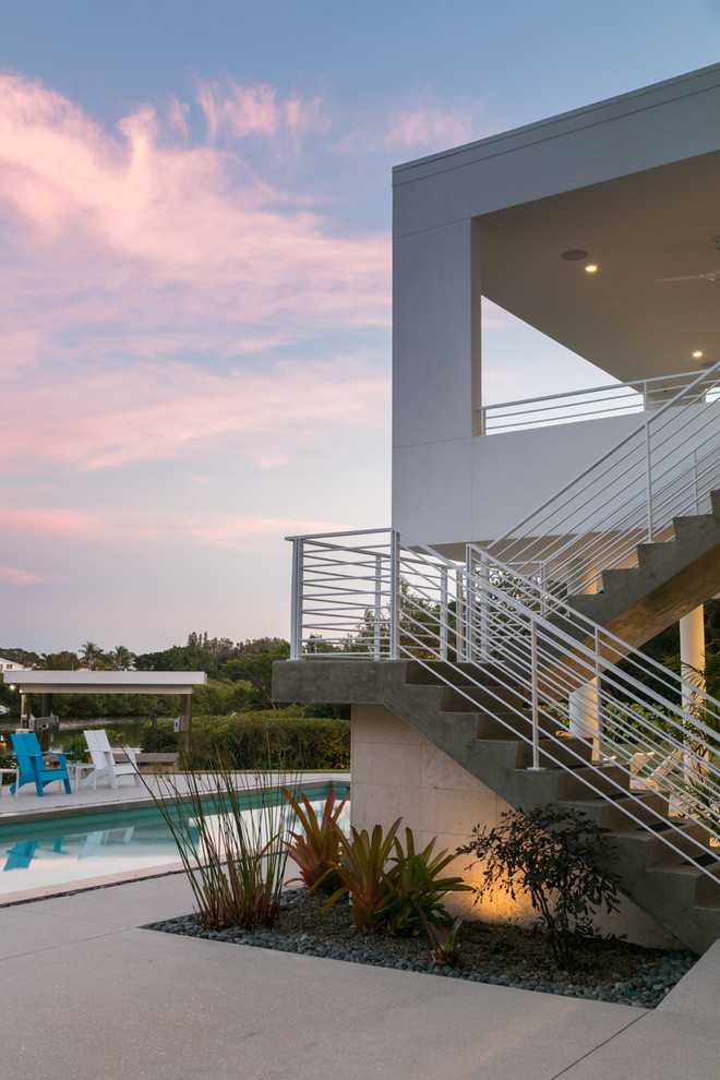 Inspiration for a mid-sized beach style concrete floating staircase in Tampa with concrete risers and metal railing.