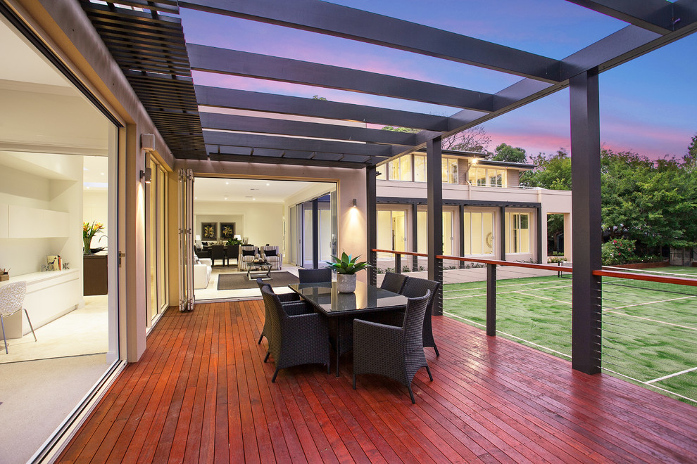 This is an example of a contemporary backyard deck in Sydney with a pergola.