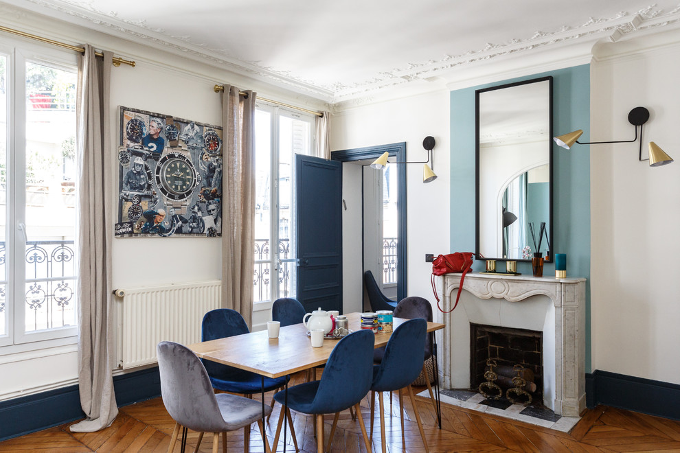 Inspiration for a contemporary separate dining room in Paris with white walls, medium hardwood floors, a standard fireplace, a brick fireplace surround and brown floor.