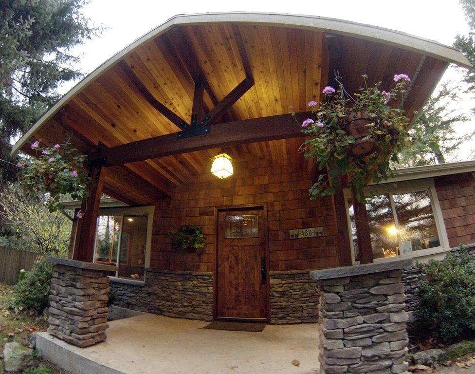 Photo of a mid-sized traditional front yard verandah in Seattle with a roof extension.