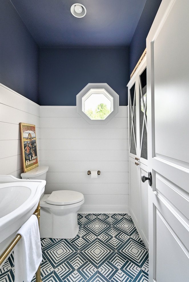 Inspiration for a small nautical cloakroom in Milwaukee with a two-piece toilet, blue walls, cement flooring, a console sink, blue floors, a freestanding vanity unit and tongue and groove walls.