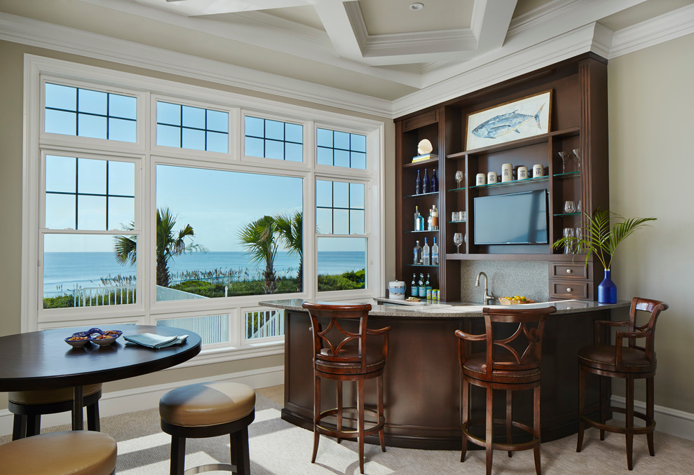 This is an example of a small tropical seated home bar in Miami with open cabinets, dark wood cabinets and beige floor.