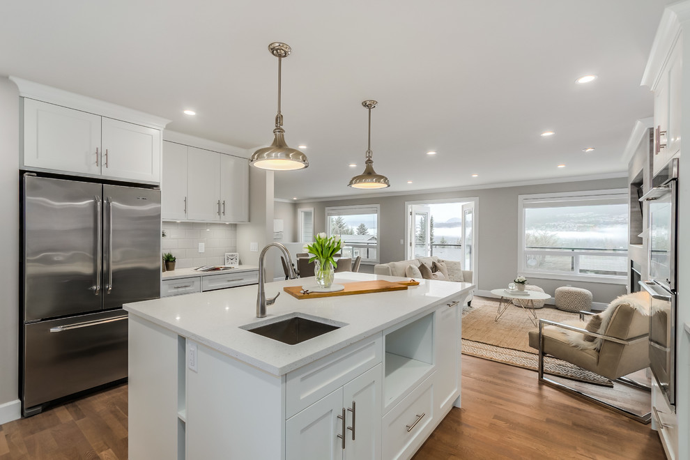 Large transitional u-shaped medium tone wood floor eat-in kitchen photo in Vancouver with a double-bowl sink, shaker cabinets, white cabinets, quartz countertops, gray backsplash, ceramic backsplash, stainless steel appliances and an island