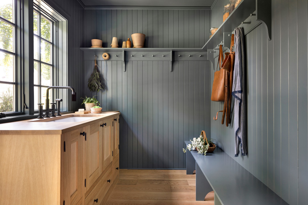 Idée de décoration pour une entrée champêtre avec un vestiaire, un mur bleu, parquet clair, un sol marron et du lambris de bois.