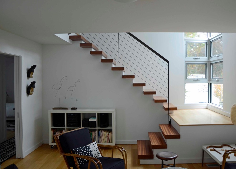 This is an example of a mid-sized modern wood l-shaped staircase in New York with painted wood risers.