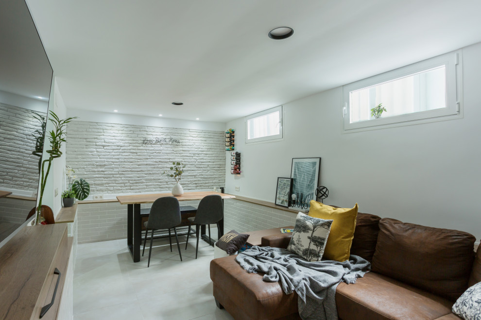 Kleines, Abgetrenntes Industrial Wohnzimmer mit Hausbar, weißer Wandfarbe, Porzellan-Bodenfliesen, Hängekamin, TV-Wand, grauem Boden und Ziegelwänden in Madrid
