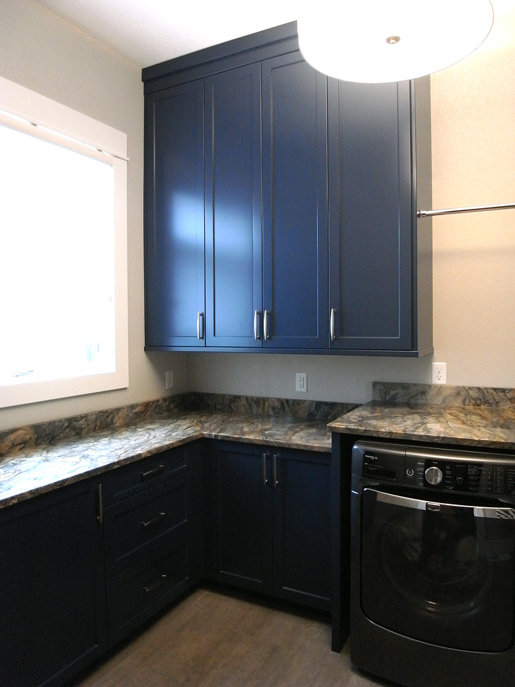 Dedicated laundry room - small transitional l-shaped dedicated laundry room idea with blue cabinets, a side-by-side washer/dryer and flat-panel cabinets